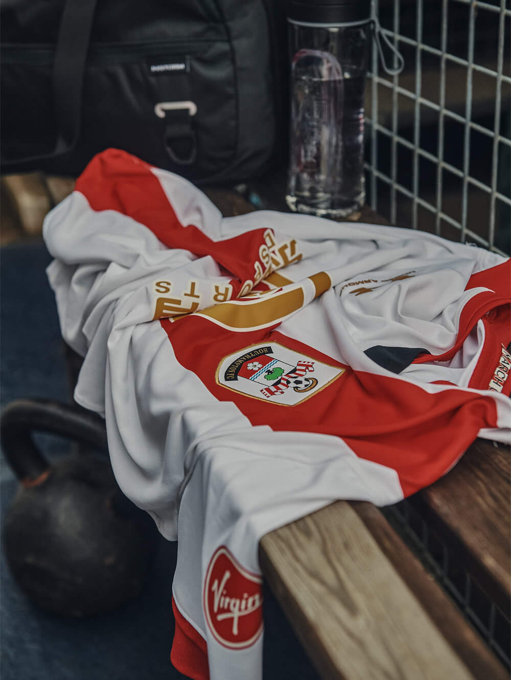 white and red southampton fc football shirt draped over a gym bench